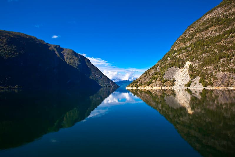 Sognefjord stretching into the distance between green mountain ridges under a blue sky