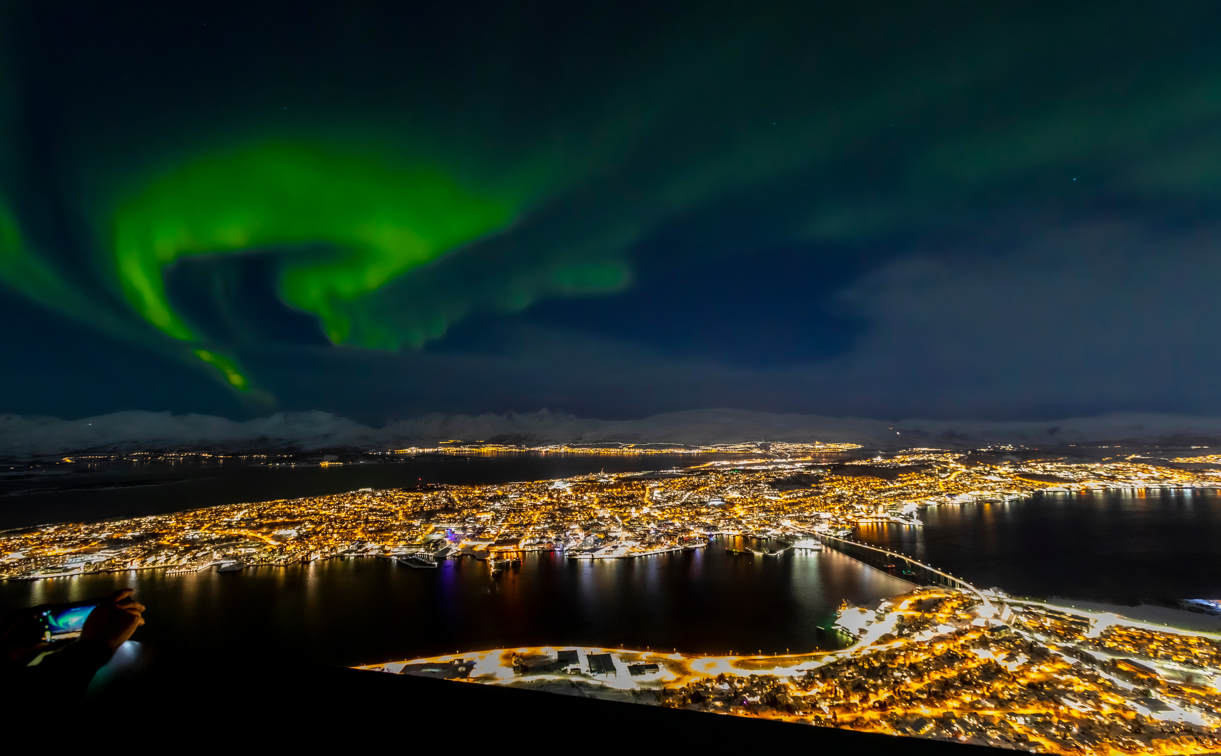 Tromsø city lights below the Sherpa Stairs route up Fløyfjellet, aurora overhead